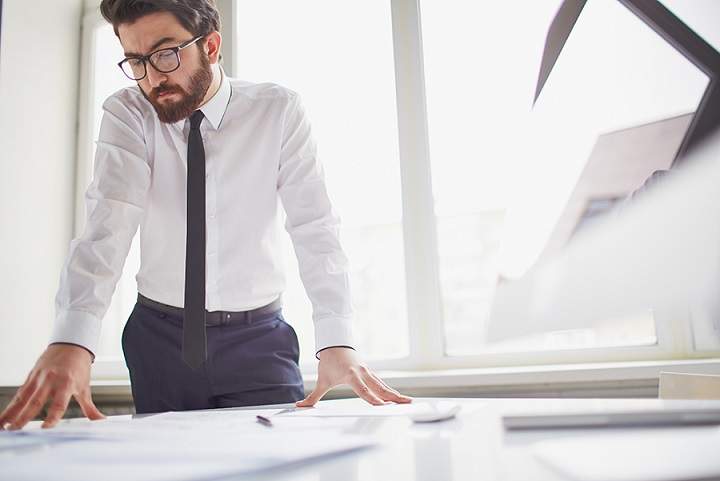 man standing at desk working