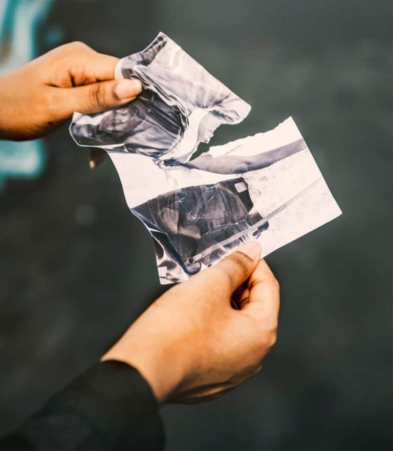 woman ripping photo of couple in half