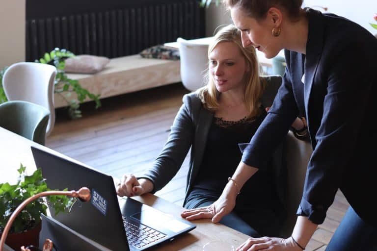 business women talking looking at laptop