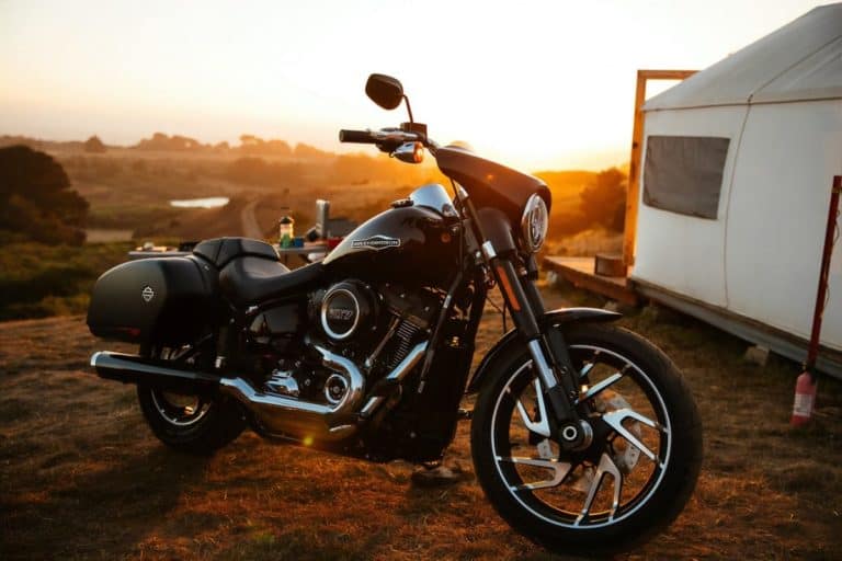 Harley Davidson bike in mountain top next to cabin tent