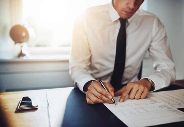 business man sitting at his desk looking at statistic