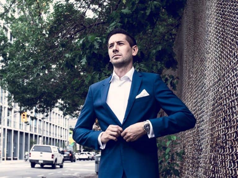 business man walking on the street doing up his jacket button