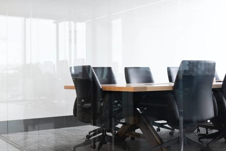 boardroom with office chairs at boardroom table with glass wall