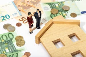 two small human statues standing in front of house with surrounding them