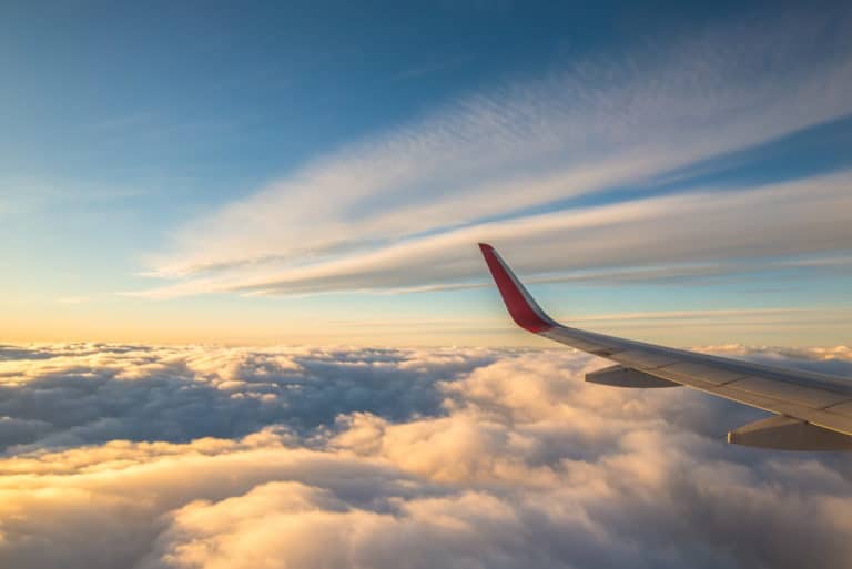 an airplane wing in the sky above the clouds