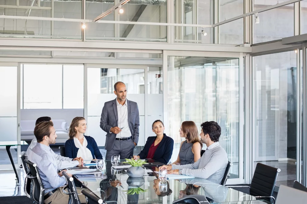 business meeting with group of people sitting at a glass table