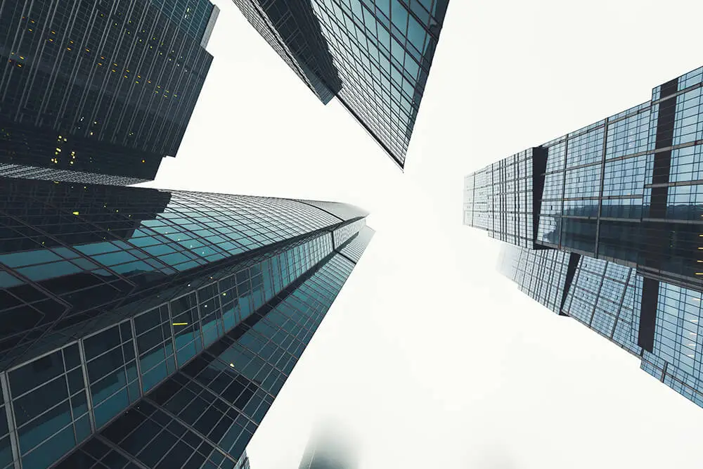 looking up at two city skyscrapers from the ground