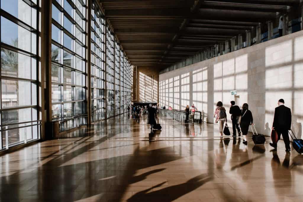 Temporary visa holders walking through an airport.