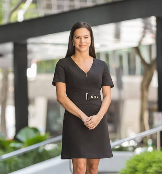 A woman in a black dress standing in front of a building.