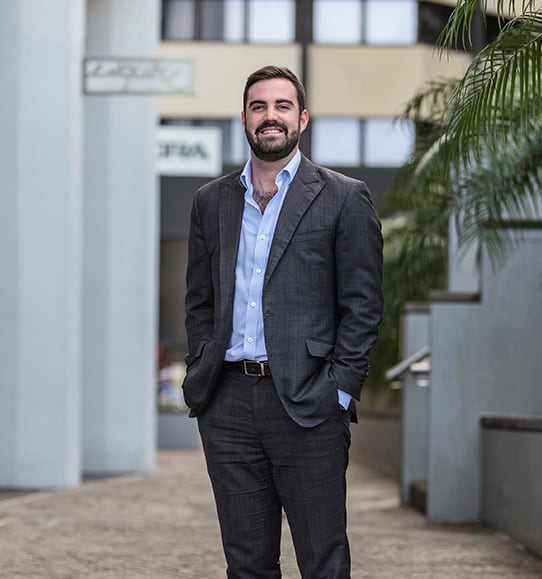 A man in a suit standing in front of a building.