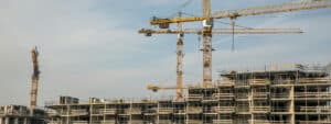 a picture of cranes and ongoing buildings with construction issues with the blue sky as background