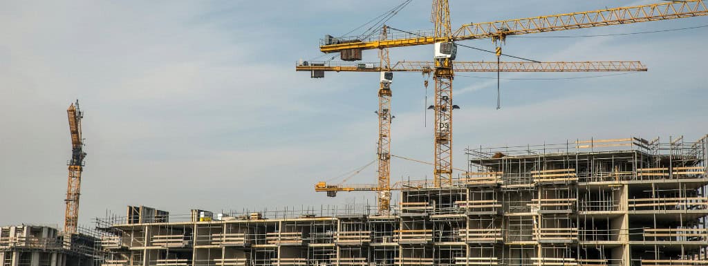 a picture of cranes and ongoing buildings with construction issues with the blue sky as background
