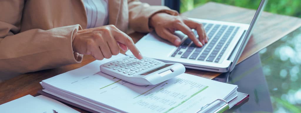 person with calculator and laptop
